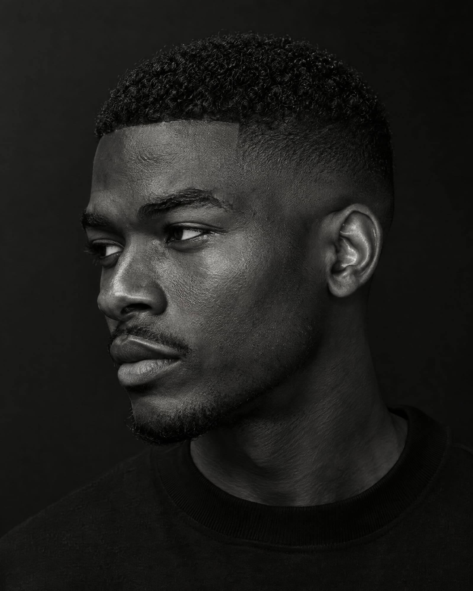 Black-and-white close-up of a low skin fade.