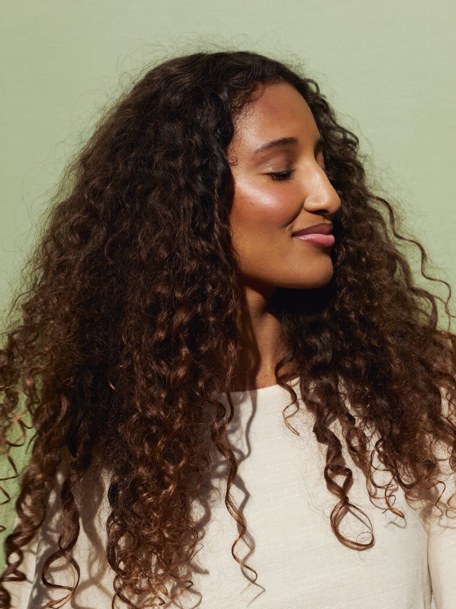 Defined spiral curls on a client with her eyes closed.