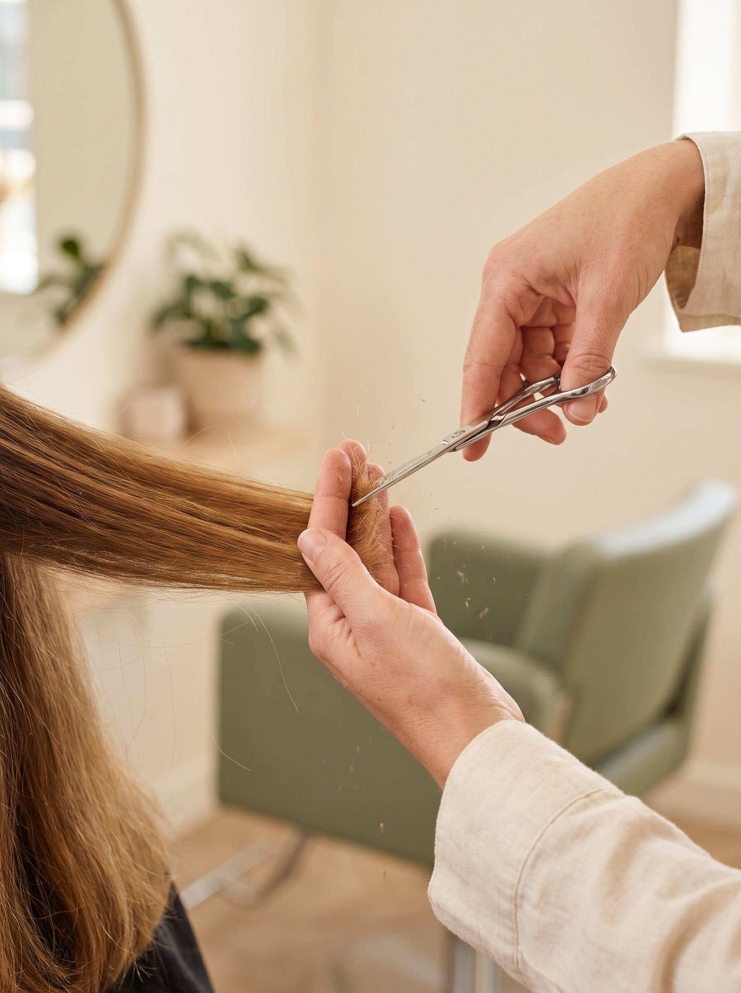 A stylist precision-cutting honey-brown hair.